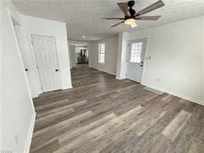 interior space featuring ceiling fan, dark hardwood / wood-style floors, and a textured ceiling