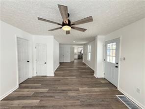 interior space with dark wood-type flooring and a textured ceiling