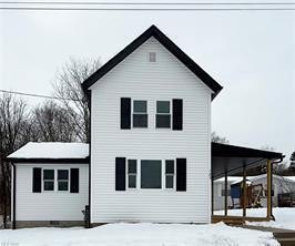 view of snow covered rear of property