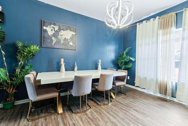 dining room with hardwood / wood-style floors and an inviting chandelier