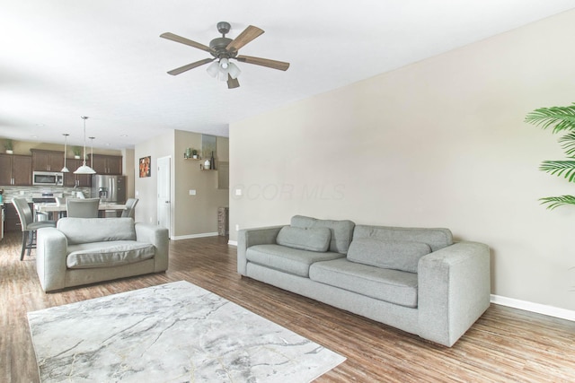 living room with hardwood / wood-style flooring and ceiling fan