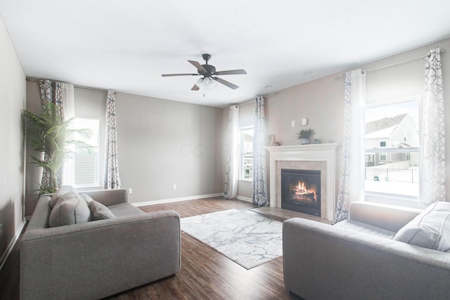 living room featuring hardwood / wood-style floors, ceiling fan, a wealth of natural light, and a high end fireplace