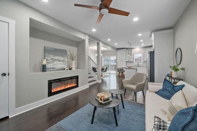 living room with ceiling fan, dark hardwood / wood-style floors, and sink