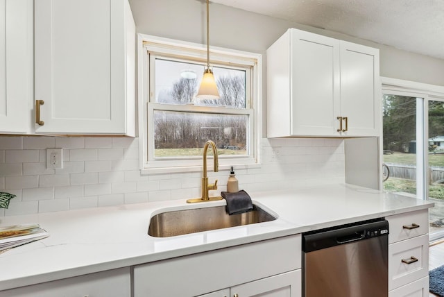 kitchen featuring sink, hanging light fixtures, plenty of natural light, white cabinets, and stainless steel dishwasher