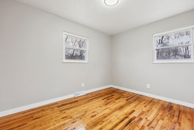 empty room featuring hardwood / wood-style flooring and a wealth of natural light