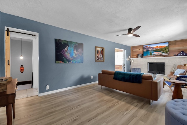 living room with hardwood / wood-style flooring, ceiling fan, and a textured ceiling