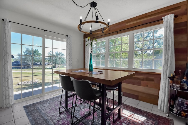 dining room featuring a wealth of natural light, a textured ceiling, a chandelier, and light tile patterned floors