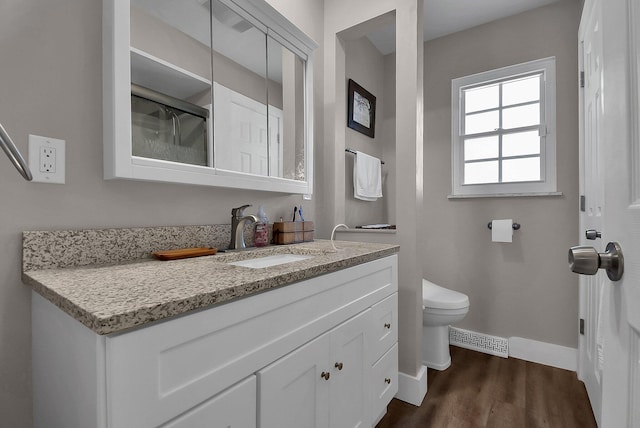 bathroom featuring vanity, hardwood / wood-style flooring, and toilet