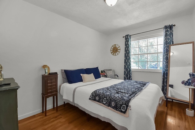 bedroom with hardwood / wood-style flooring and a textured ceiling