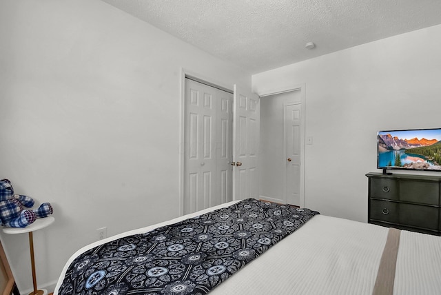 bedroom with a textured ceiling and a closet