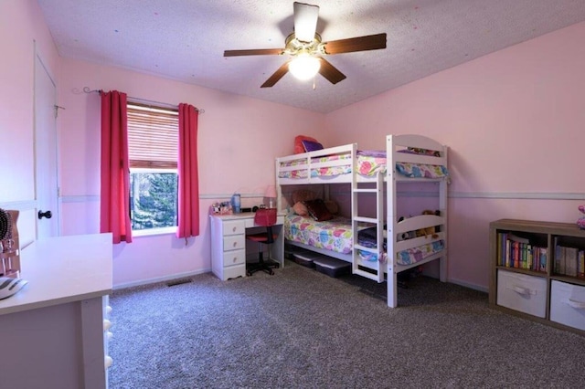 carpeted bedroom featuring ceiling fan and a textured ceiling