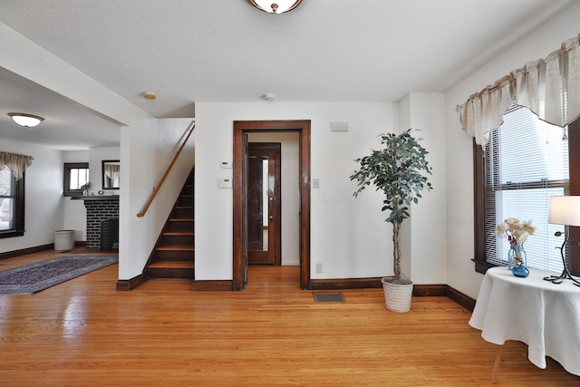 foyer featuring a fireplace and light wood-type flooring