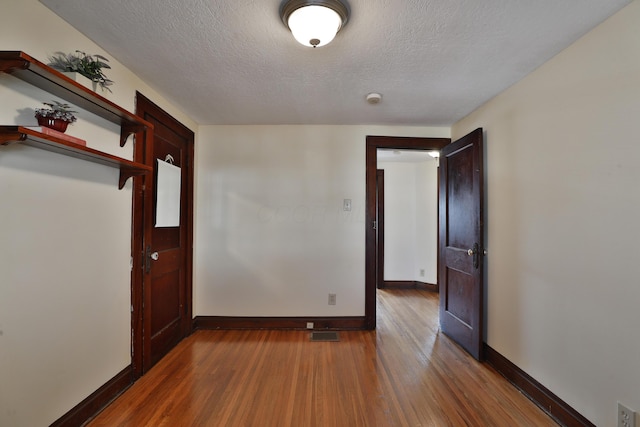 unfurnished bedroom featuring hardwood / wood-style floors and a textured ceiling