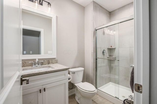 bathroom featuring a stall shower, vanity, and toilet