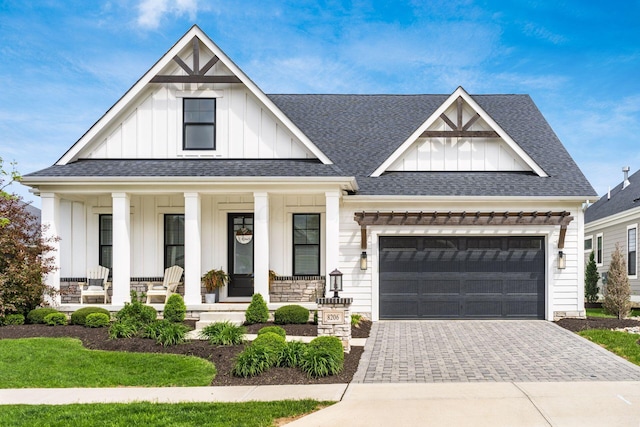 modern inspired farmhouse with board and batten siding, a porch, driveway, a garage, and a shingled roof