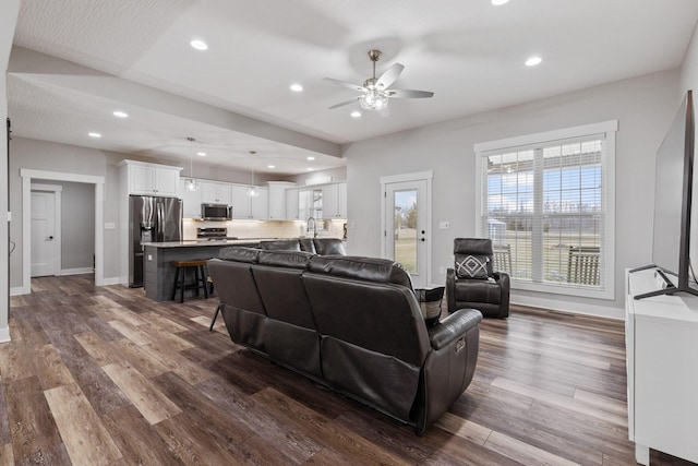 living room with dark wood-type flooring and ceiling fan