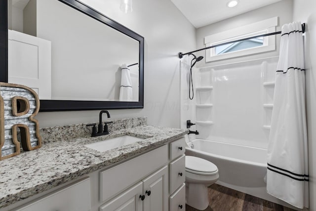 full bathroom featuring vanity, hardwood / wood-style floors, shower / tub combo, and toilet