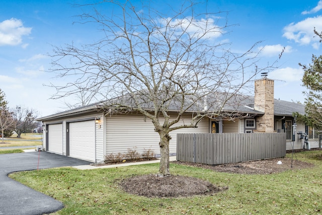 view of home's exterior featuring a garage and a lawn