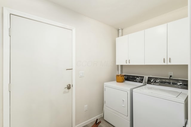 clothes washing area with cabinets and washing machine and dryer