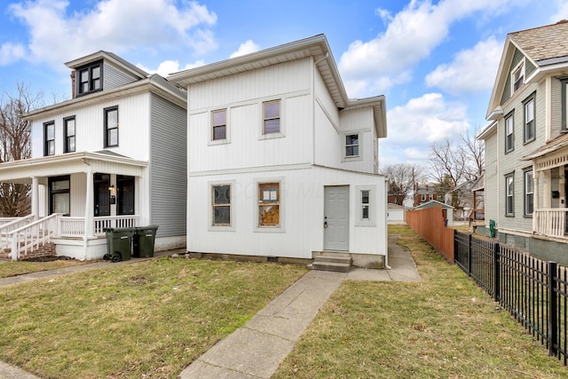 view of front facade featuring entry steps, covered porch, fence, and a front yard