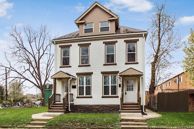 traditional style home with brick siding, fence, and a front lawn