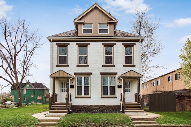 traditional style home with a front yard, brick siding, and fence