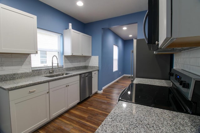 kitchen featuring sink, white cabinetry, stainless steel appliances, light stone countertops, and dark hardwood / wood-style flooring