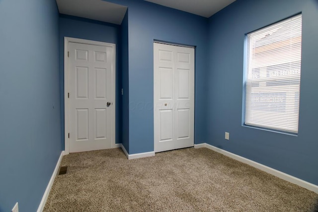 unfurnished bedroom featuring carpet floors and a closet