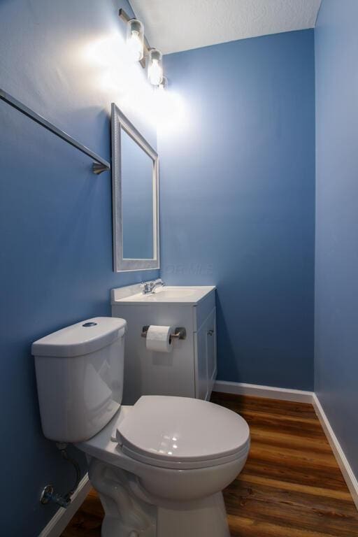 bathroom with vanity, wood-type flooring, and toilet