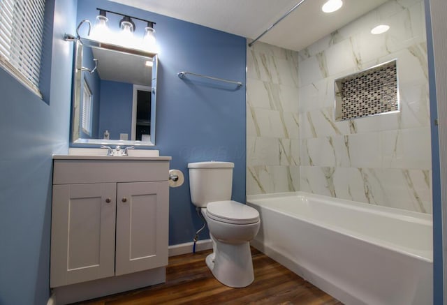 full bathroom featuring tiled shower / bath, hardwood / wood-style floors, vanity, and toilet