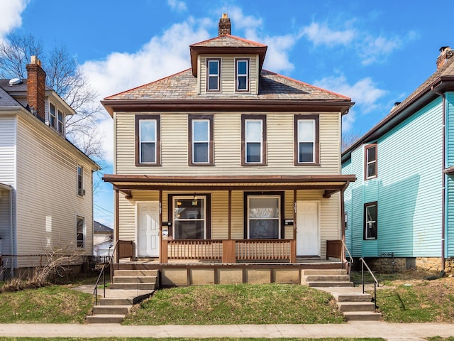 traditional style home with covered porch, a chimney, and fence