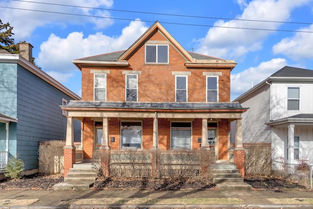 view of front of property with covered porch, brick siding, and fence