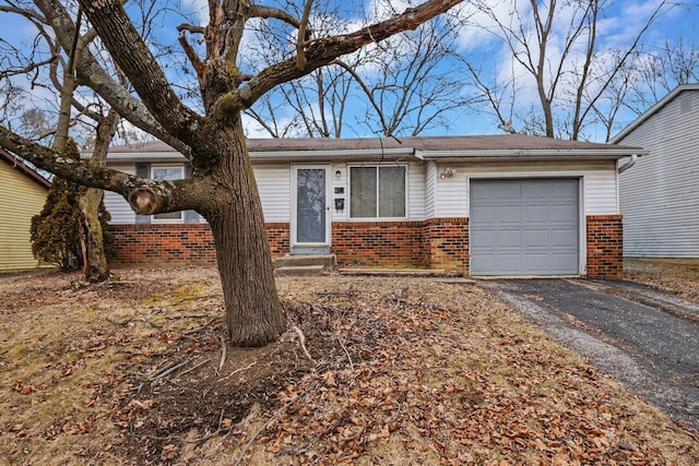 ranch-style house with a garage, aphalt driveway, and brick siding