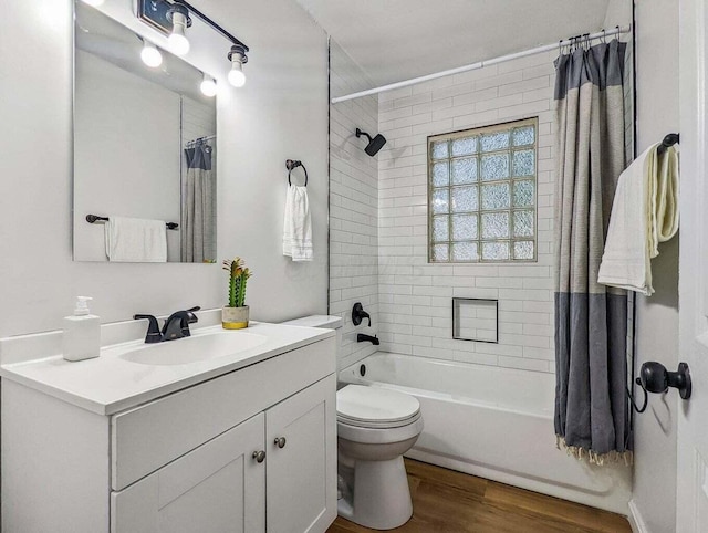 full bathroom featuring vanity, hardwood / wood-style floors, shower / bath combination with curtain, and toilet