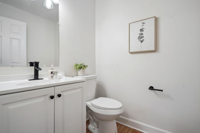 bathroom featuring toilet, vanity, and wood-type flooring