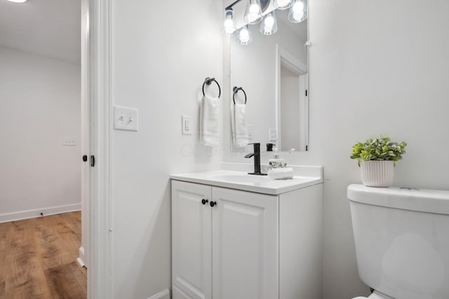 bathroom featuring wood-type flooring, vanity, and toilet