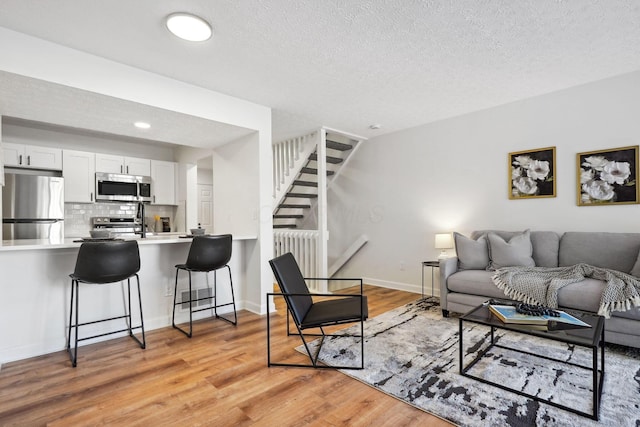 living room featuring light hardwood / wood-style floors and a textured ceiling