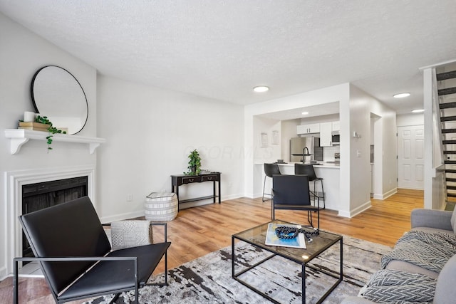 living room featuring light hardwood / wood-style floors and a textured ceiling