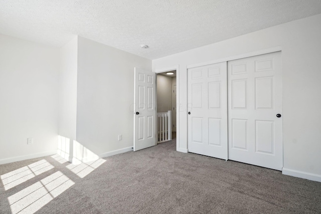 unfurnished bedroom with carpet, a closet, and a textured ceiling