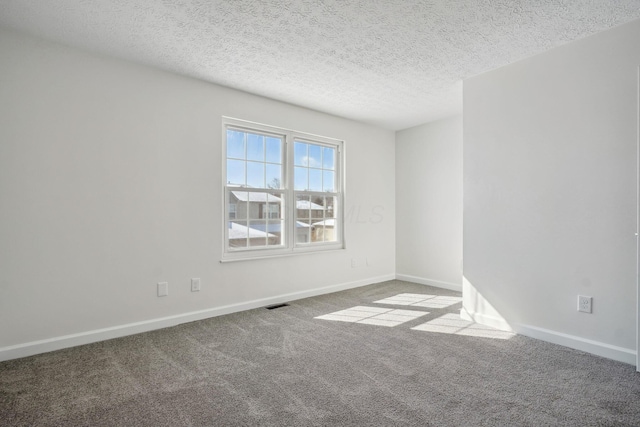 carpeted spare room with a textured ceiling