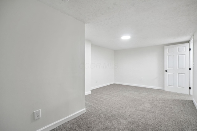 carpeted empty room featuring a textured ceiling