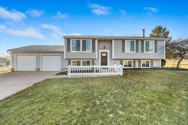 split foyer home with a garage, metal roof, concrete driveway, and a front yard