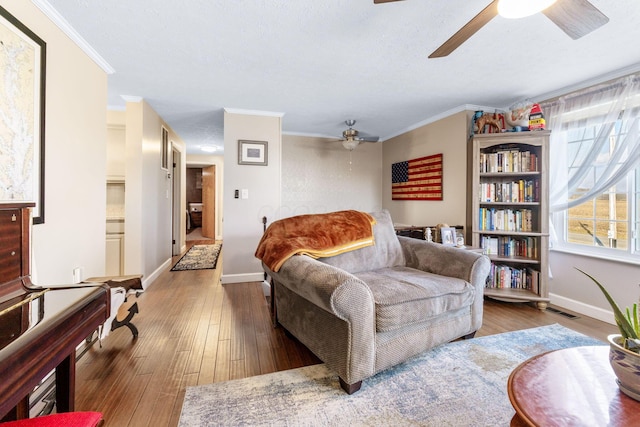 sitting room featuring ornamental molding, wood finished floors, visible vents, and baseboards