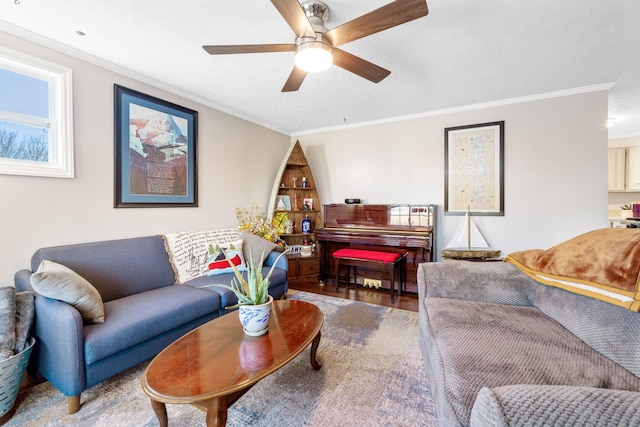 living room with ornamental molding, ceiling fan, and wood finished floors