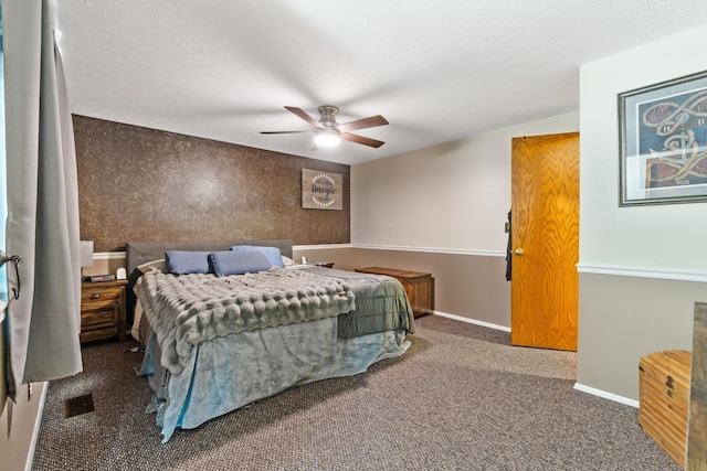 carpeted bedroom with visible vents, baseboards, ceiling fan, and a textured ceiling