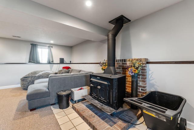 interior space featuring recessed lighting, visible vents, a wood stove, light tile patterned flooring, and baseboards