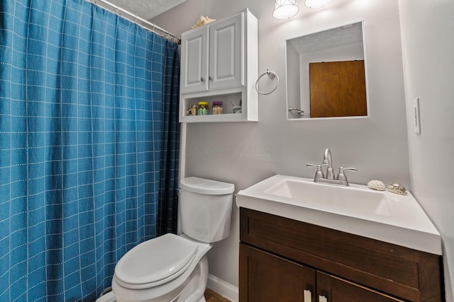 bathroom with curtained shower, vanity, and toilet