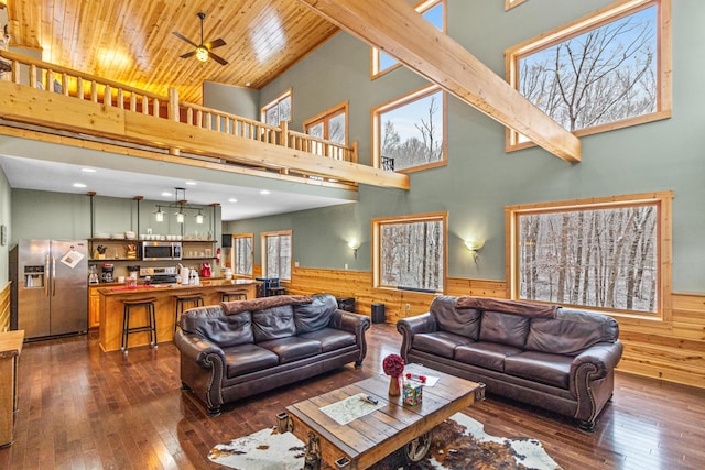 living room featuring ceiling fan, wooden walls, dark hardwood / wood-style floors, and wooden ceiling