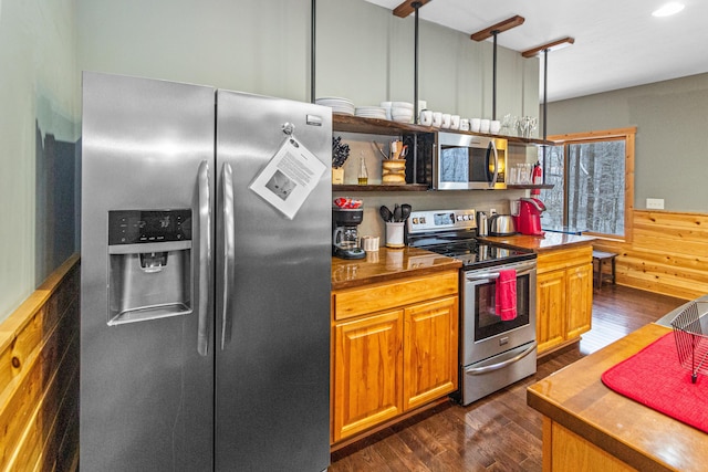 kitchen featuring stainless steel appliances, butcher block counters, and dark wood-type flooring