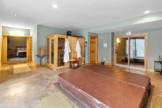 rec room featuring concrete flooring and a textured ceiling